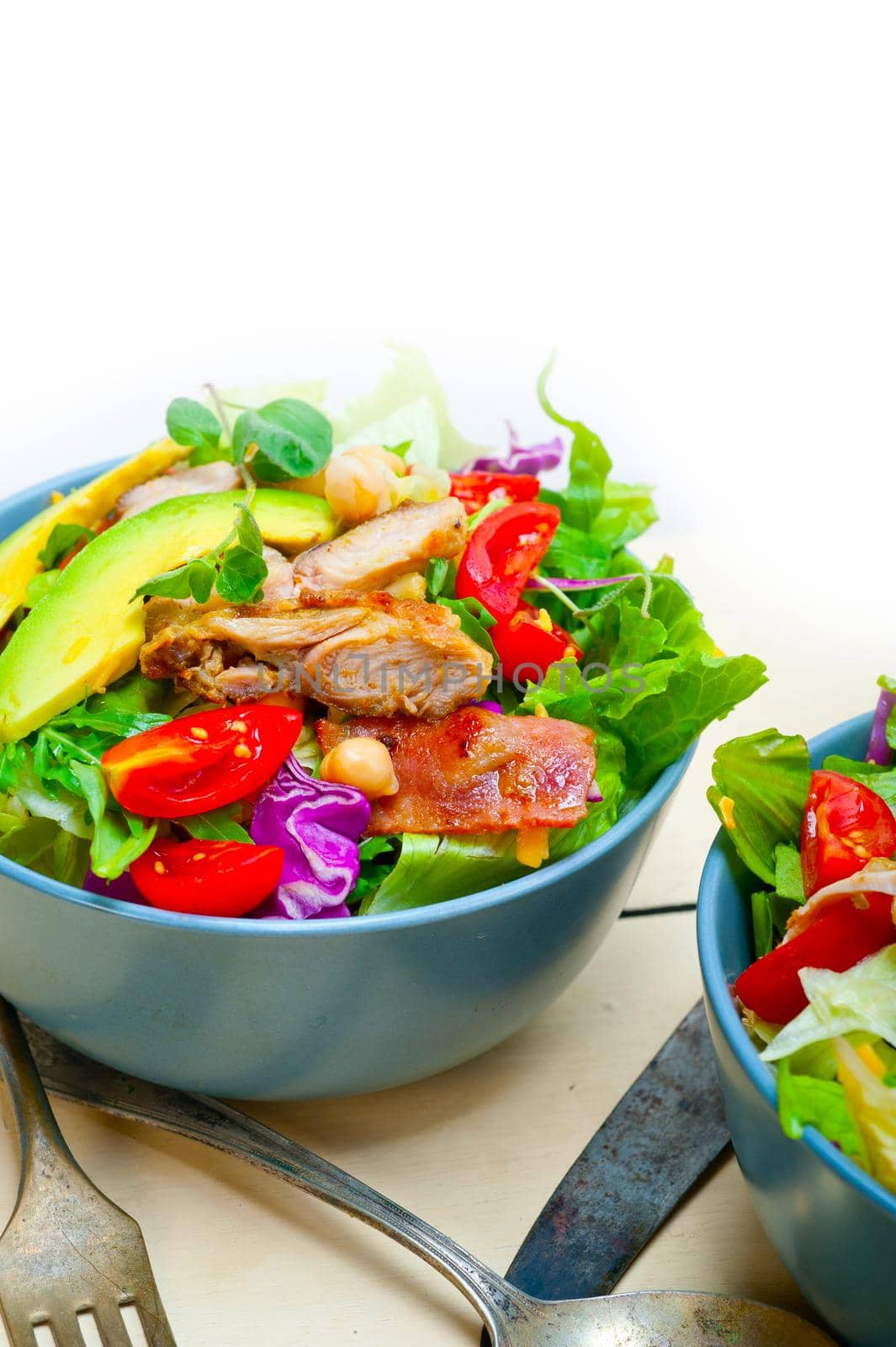 fresh and healthy Chicken Avocado salad over rustic wood table