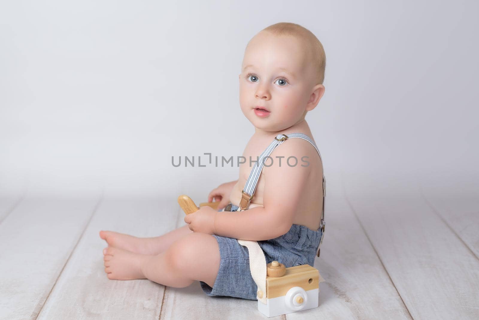 little boy with old photographic camera on white background.