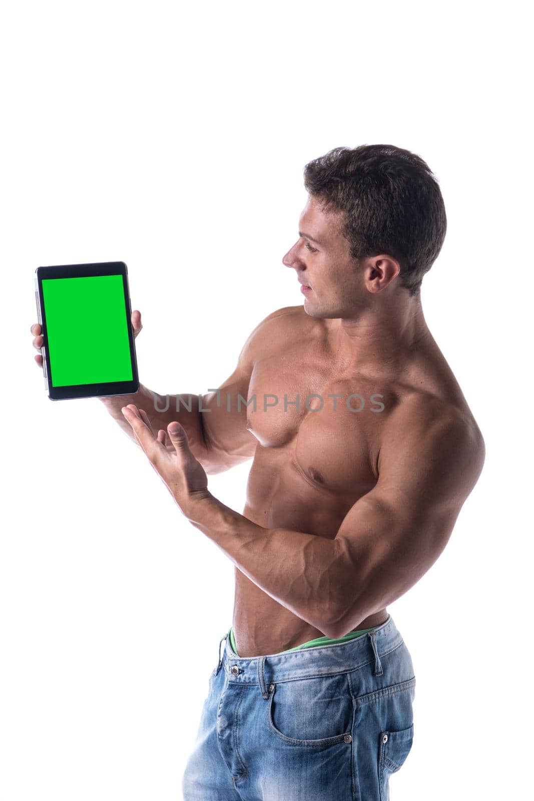 Sexy muscular shirtless young man holding a blank tablet PC while looking at camera, portrait on white