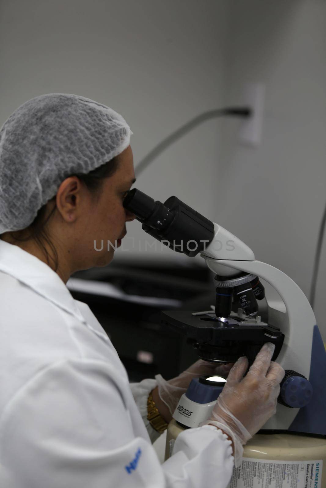 salvador, bahia, brazil - november 5, 2018: technician in laboratory makes analysis of blood under microscope of hospital in Salvador city.