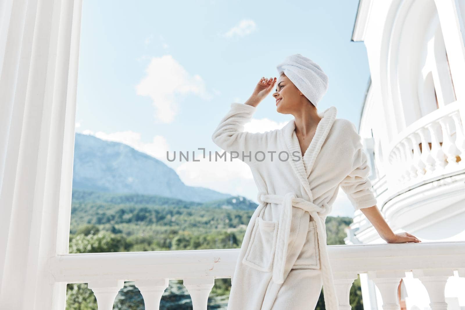Attractive young woman posing against the backdrop of mountains on the balcony architecture Lifestyle. High quality photo