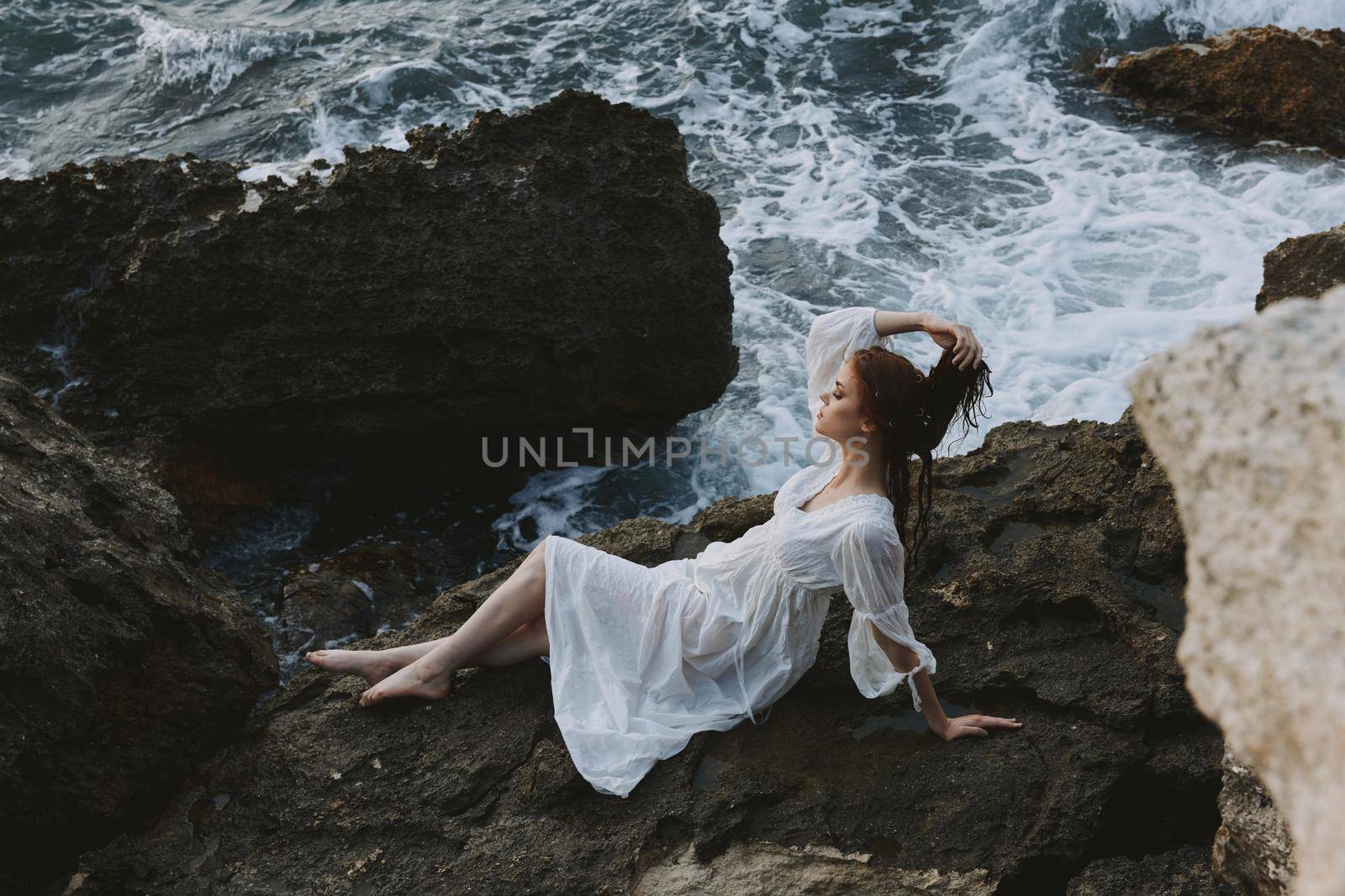 woman Lies on his back on a stone cliff, cloudy weather view from above. High quality photo