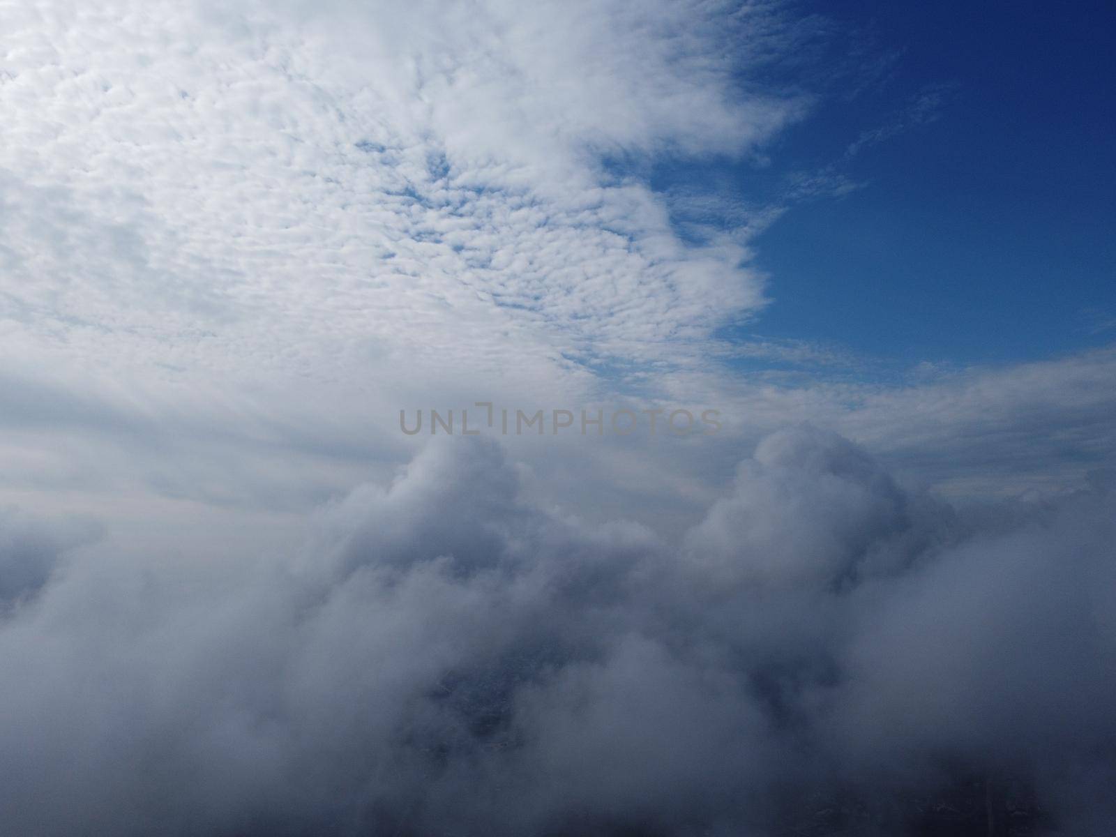 Camera is raising above from the thick fog above the beautiful ocean of clouds at sunrise. Sun is rising above the endless sea of clouds until the horizon. Amazing nature landscape, 4K drone in sky