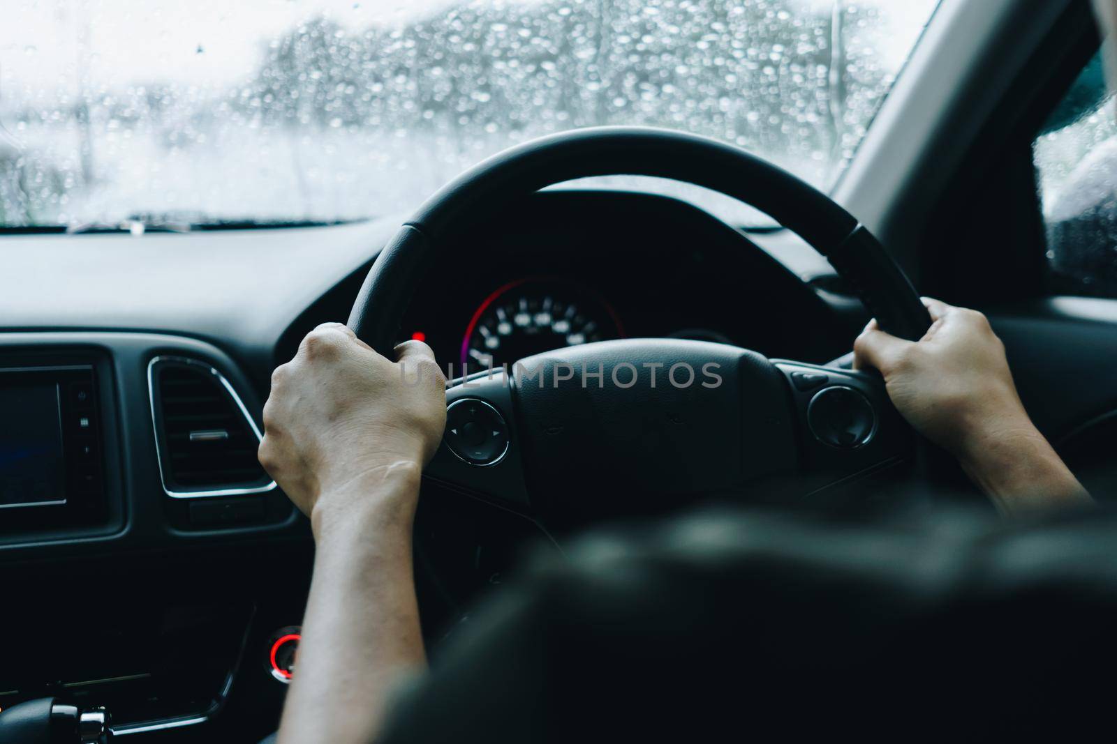 Hand of person on steering wheel drive a car with sunlight background.