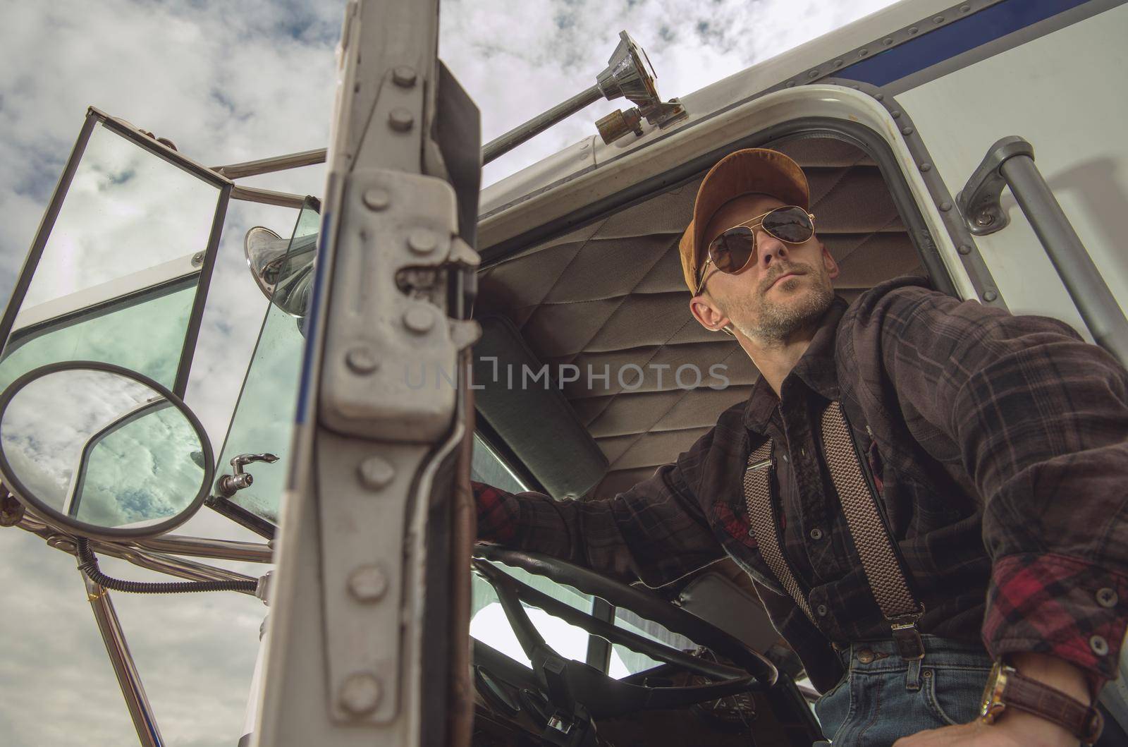 Professional Trucker Driver in Semi Truck Cabin by welcomia
