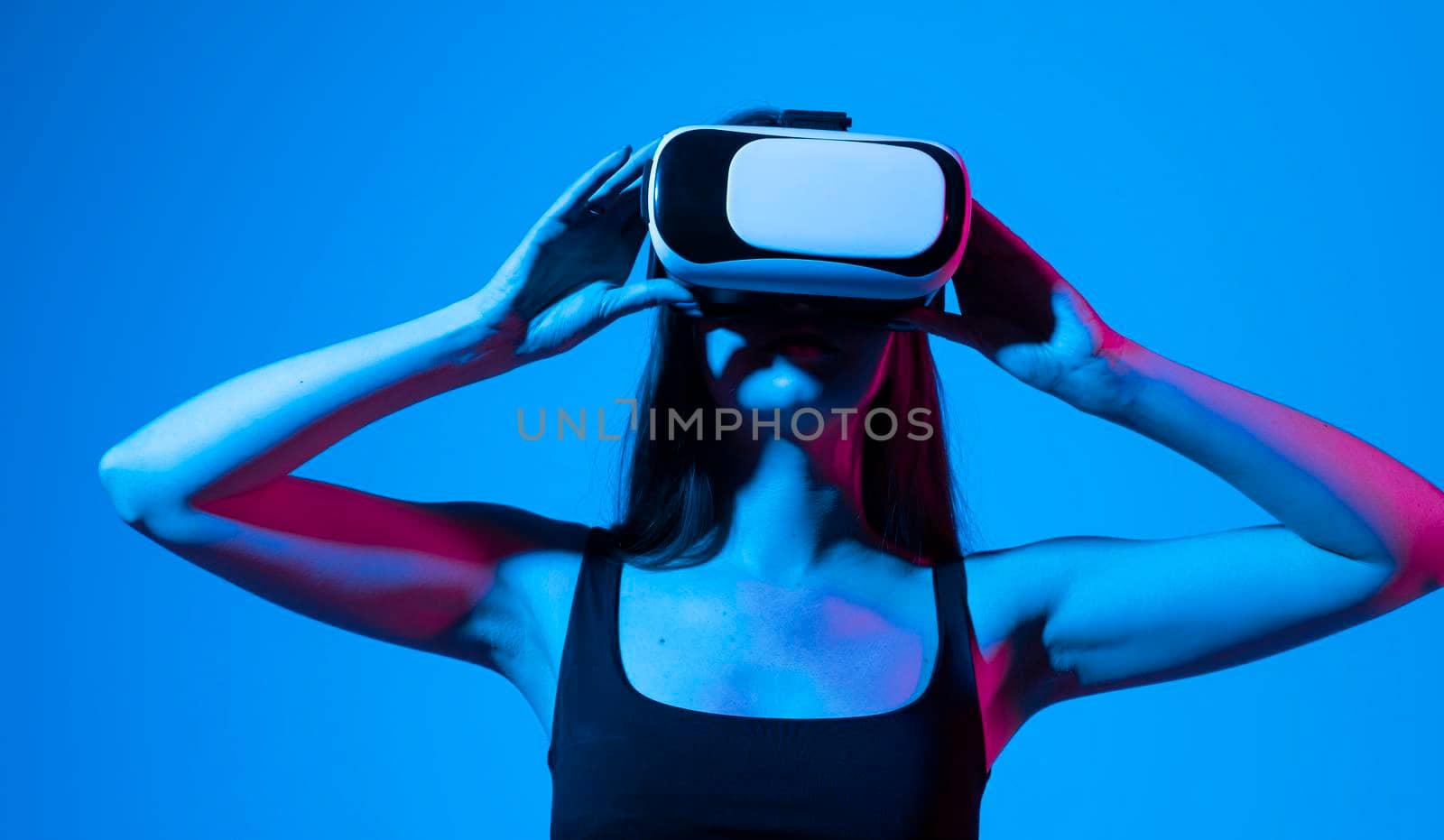 Amazed female in modern VR glasses interacting with network while having virtual reality experience. Future technology concept. Metaverse. by vovsht