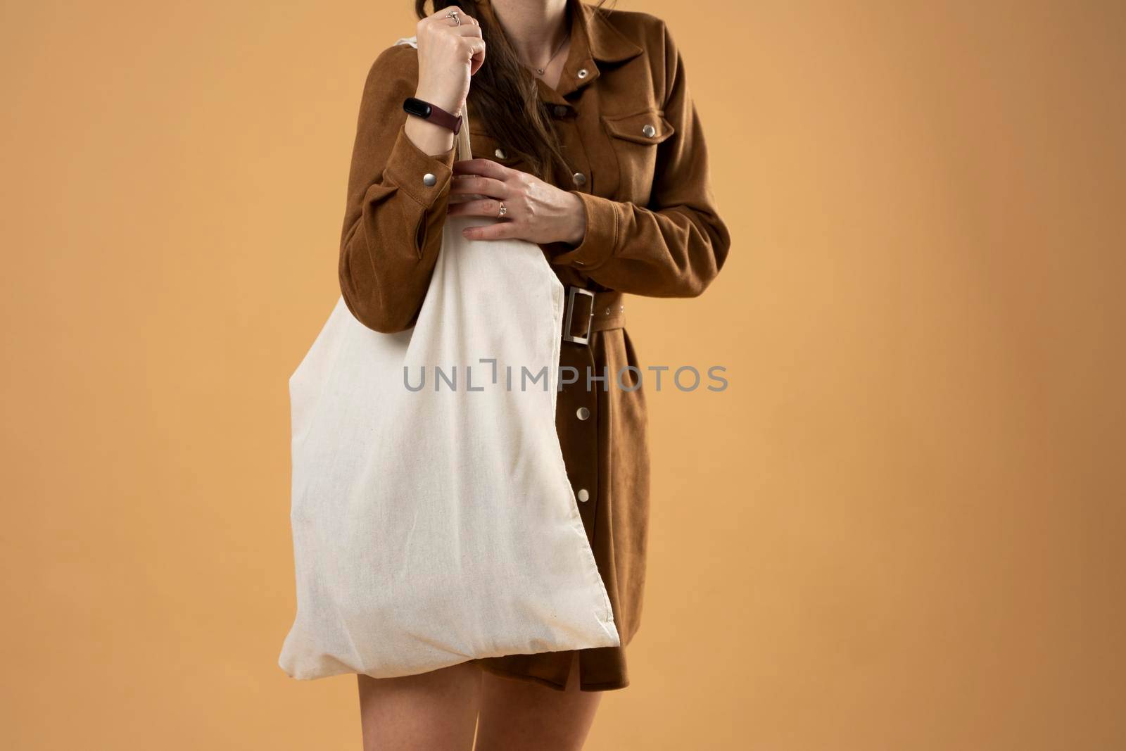 Young woman holding white cotton bag in her hands. Zero waste concept. Mockup. Eco friendly lifestyle