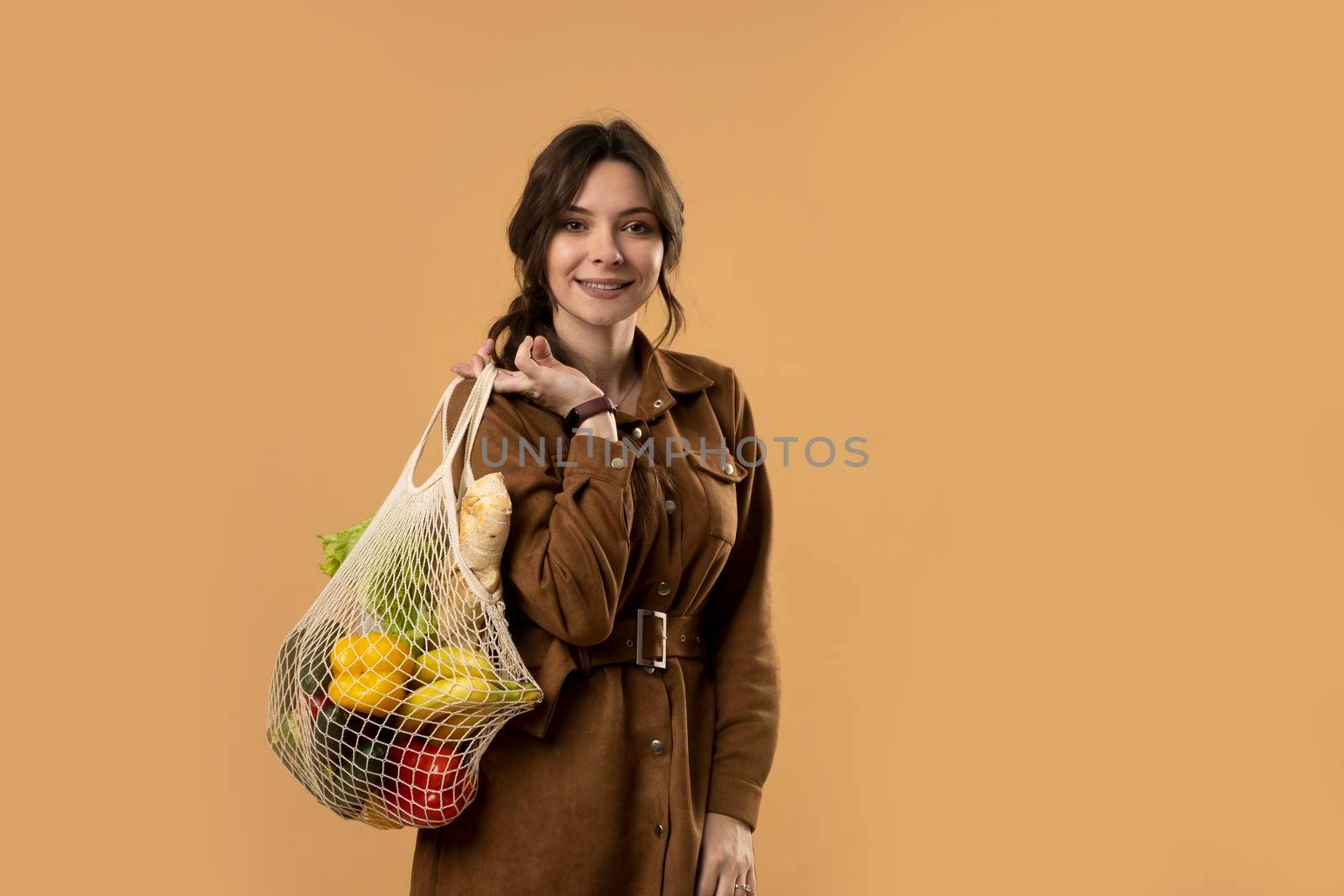 Zero waste concept. A young girl holds on her shoulder a textile mesh eco bag with a groceries. Concept of no plastic. Zero waste, plastic free. Sustainable lifestyle