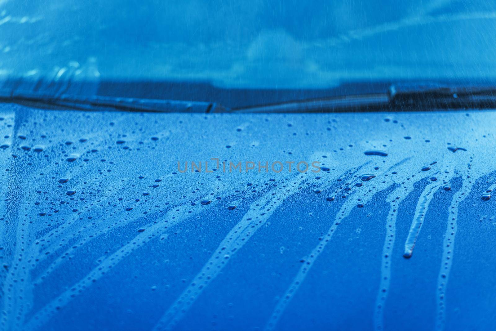 Close Image Of Wet Blue Passenger Car Hood And Windshield With Water Dripping Down.  by welcomia