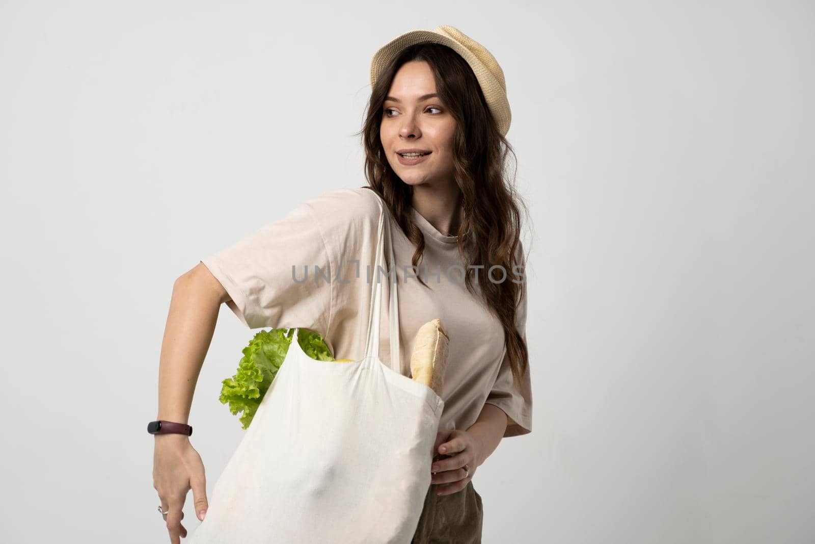Woman holding textile grocery bag with vegetables. Zero waste concept. Package-free food shopping. Eco friendly natural bag with organic fruits and vegetables. by vovsht