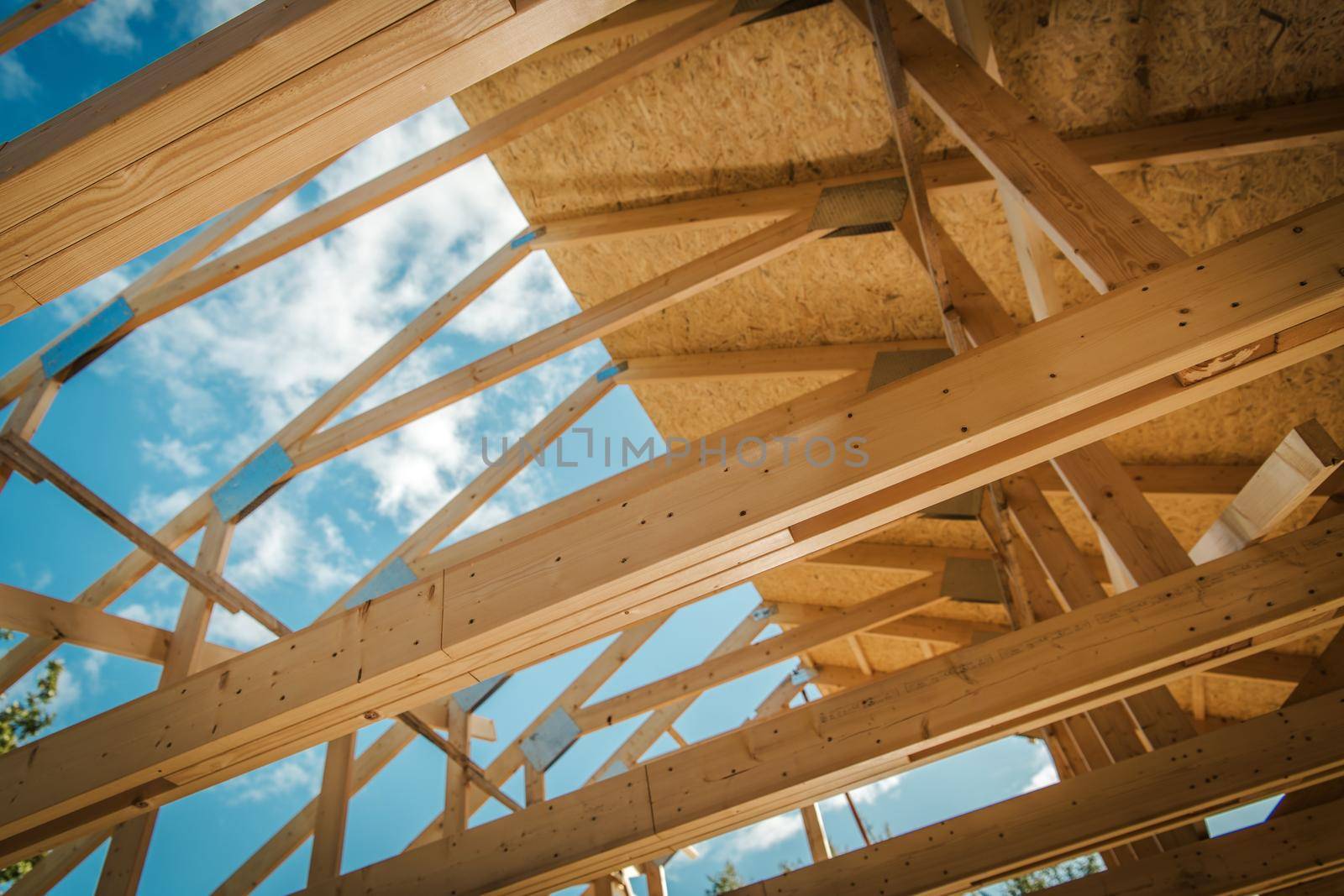 House Building. Covering Wooden Roof Structure with Plywood Boards. Closeup Photo. Construction Industry. by welcomia