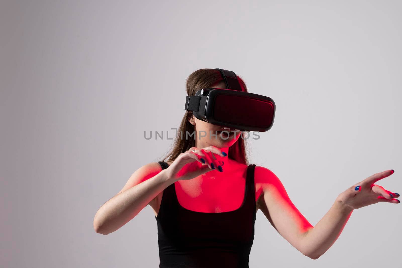 Smile happy woman getting experience using VR headset glasses of virtual reality at studio much gesticulating hands. Future technology concept. by vovsht