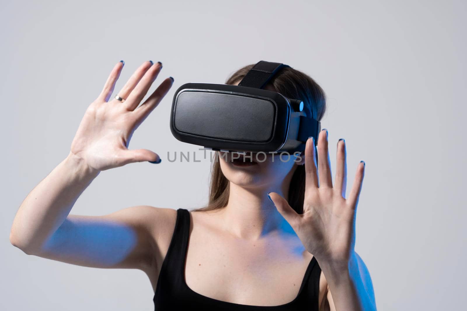 Modern architect, designer woman wearing VR goggles and interacts with metaverse using swipe and stretching gestures. Future technology concept. by vovsht