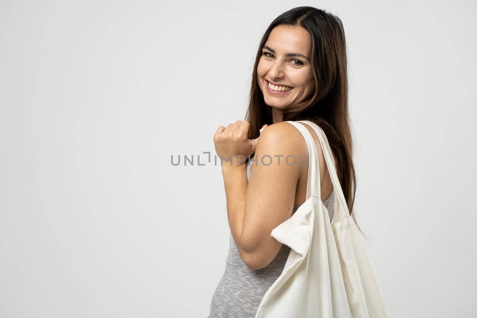 Zero waste concept with copy space. Woman holding cotton shopper with vegetables, products. Eco friendly mesh shopper. Zero waste, plastic free concept