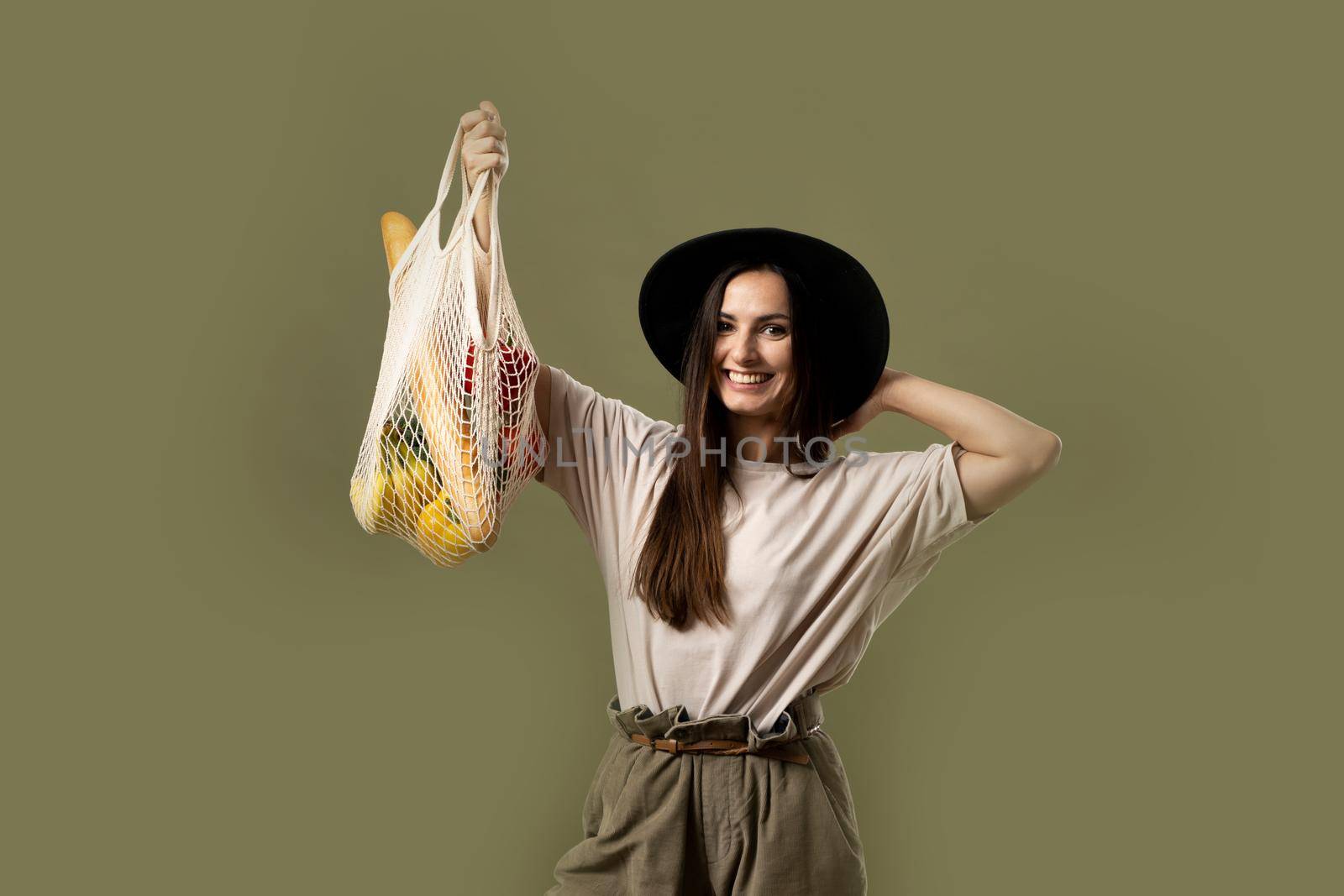 Woman with mesh eco bag with vegetables, greens and fruits without plastic bags. Zero waste, plastic free. Eco friendly concept. Sustainable lifestyle. by vovsht