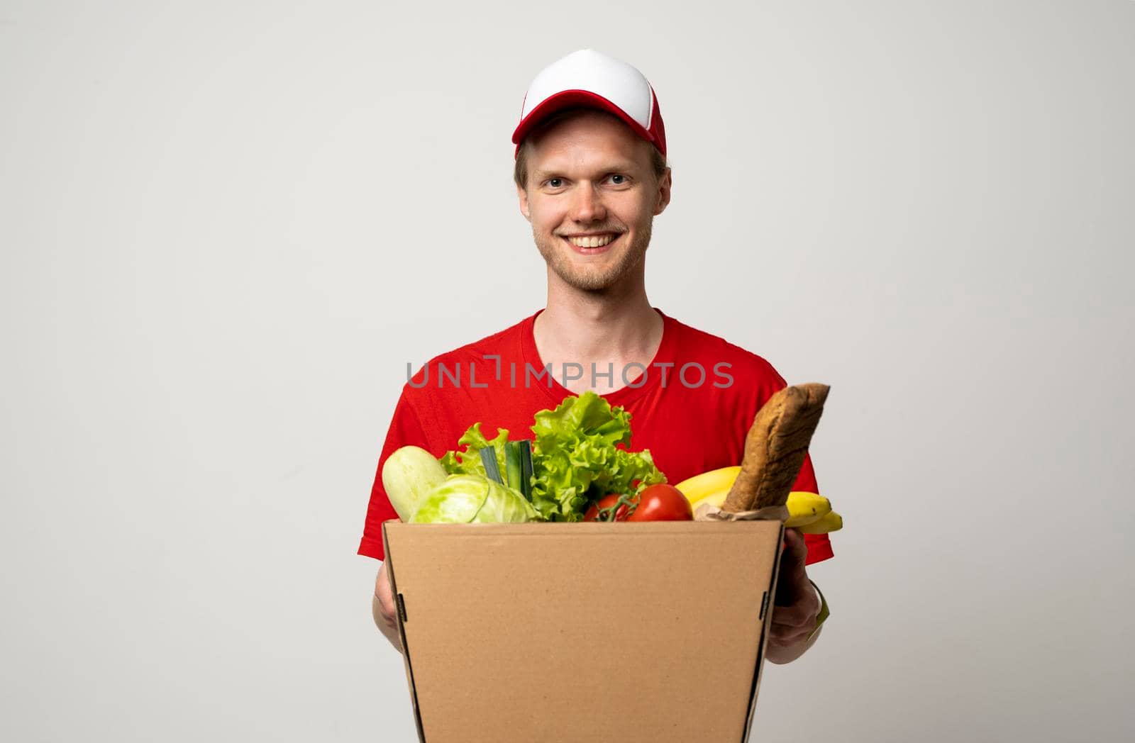 Courier carrying package box of grocery food and drink from store