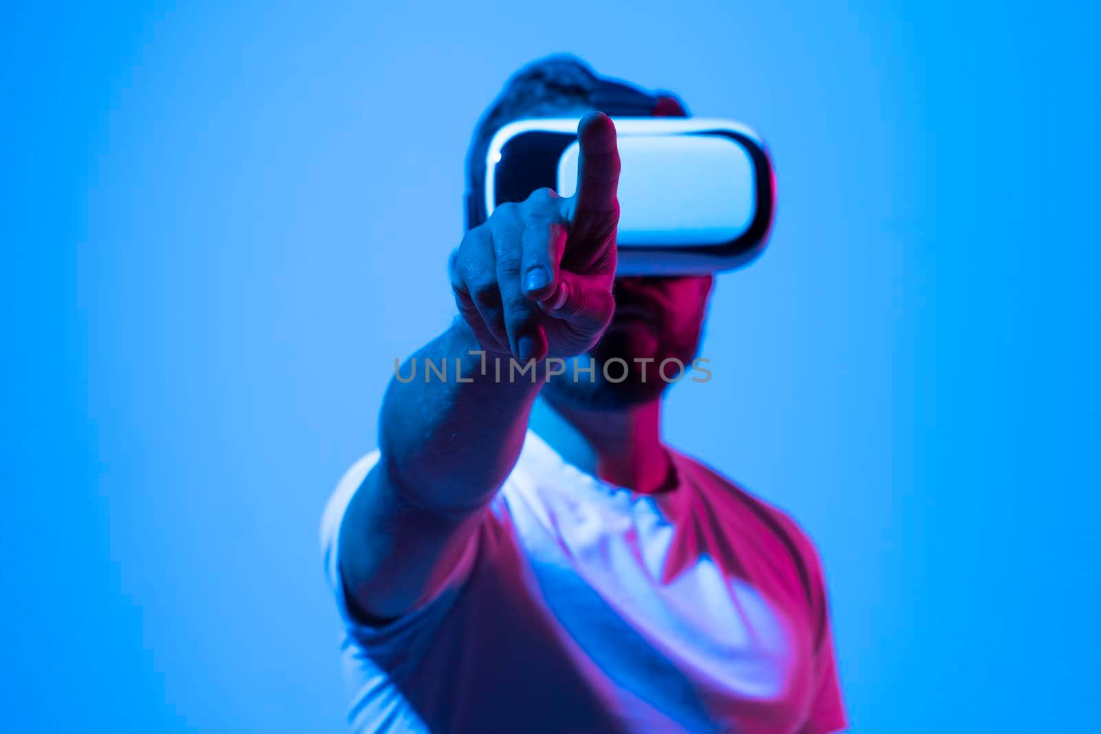 Handsome young bearded man in VR headset gesturing while working with a new project. by vovsht