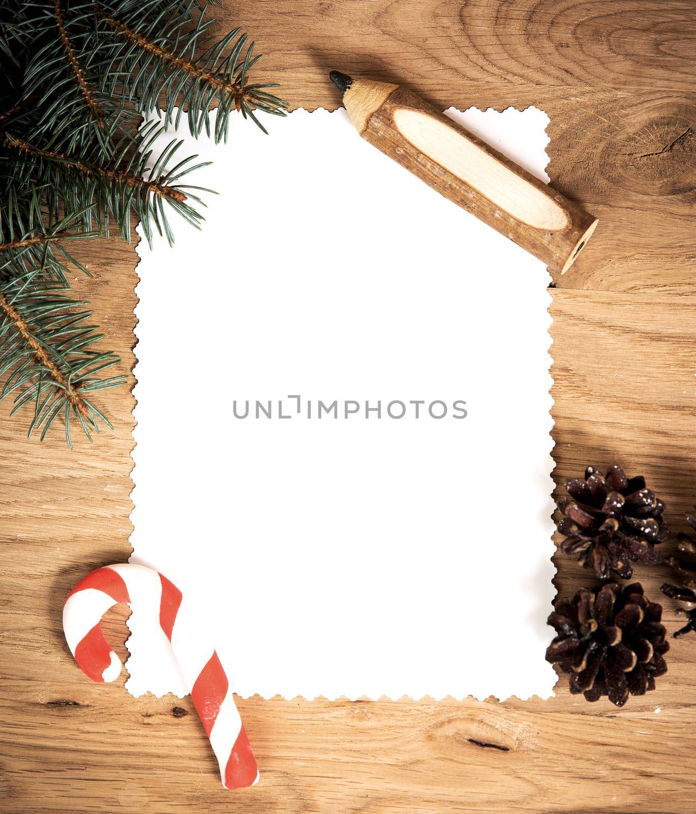 blank sheet of paper on the wooden floor with a pencil and Christmas decorations