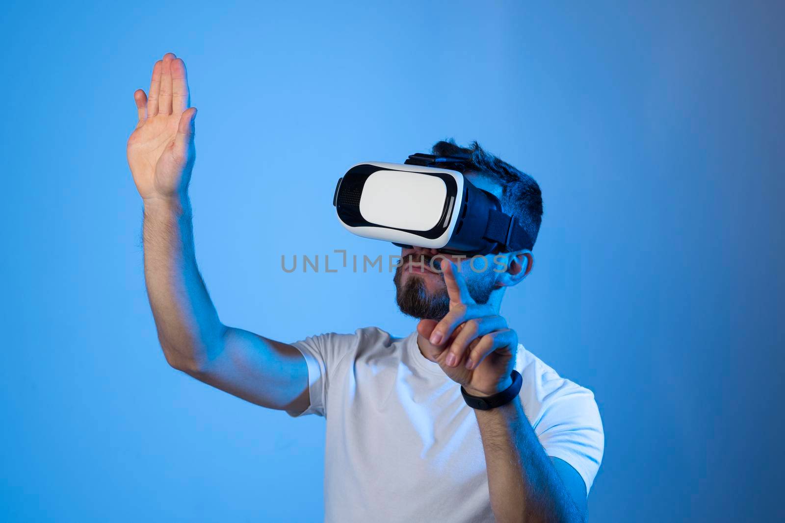 Man in virtual 3d glasses, working on imaginary display in a studio. Man playing video games at home using vr goggles