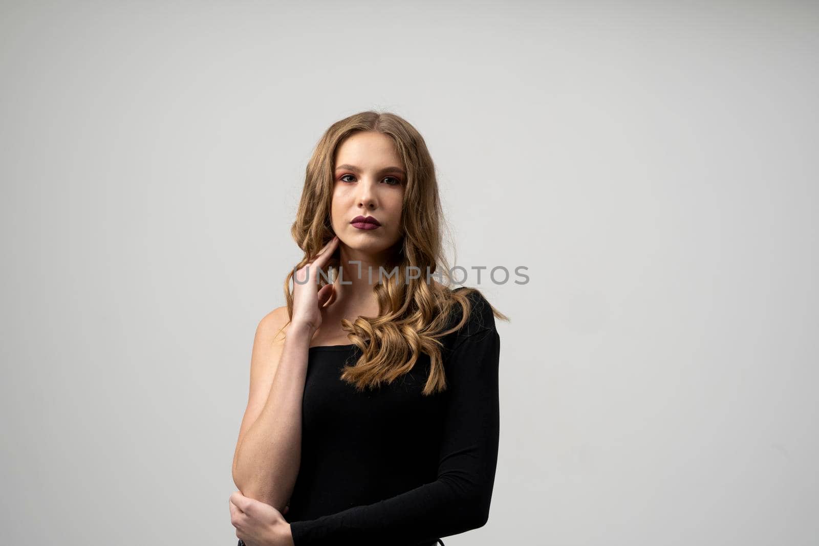 Beautiful young woman portrait in a black t-shirt. Studio shot, isolated on gray background. by vovsht