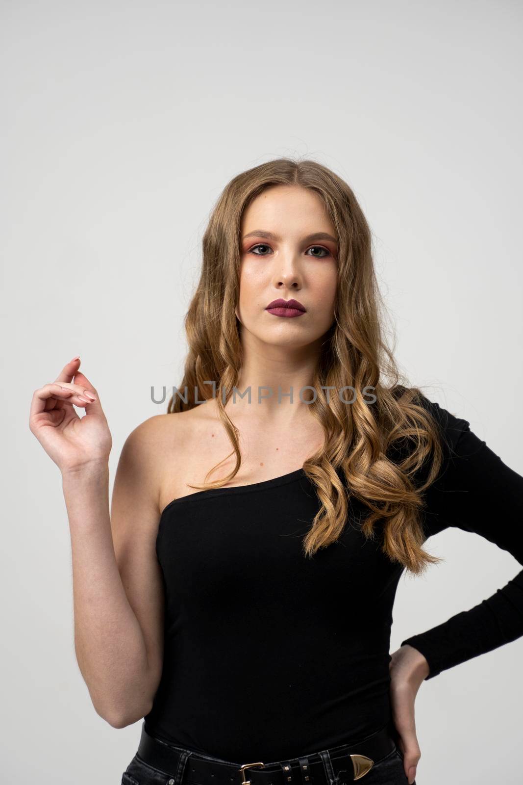 Beautiful young woman portrait in a black t-shirt. Studio shot, isolated on gray background. by vovsht