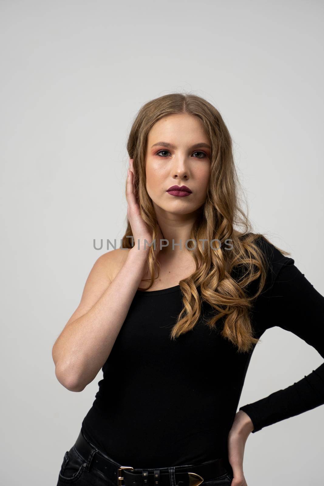 Beautiful young woman portrait in a black t-shirt. Studio shot, isolated on gray background. by vovsht
