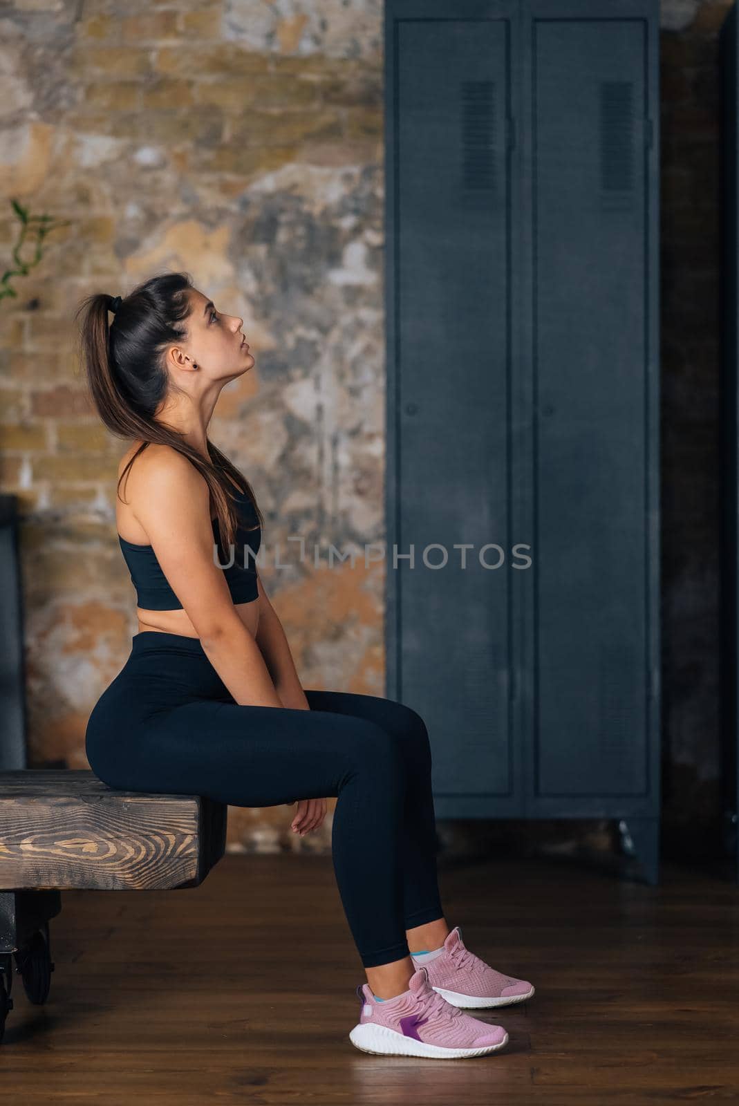 Sporty woman in sportswear resting on bench at fitness. Healthy people relax after workout. Sport and gym concept