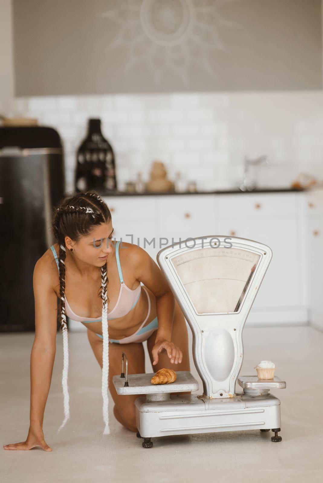 Woman in lingerie posing at the old grocery scales. Healthy eating concept by teksomolika