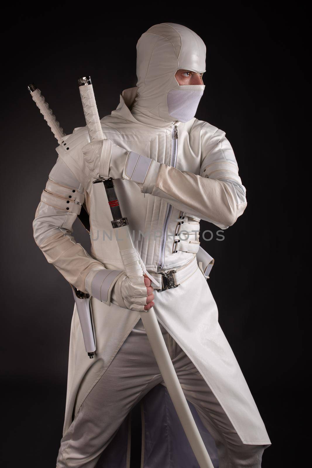 man in white ninja clothes in the studio on a black background