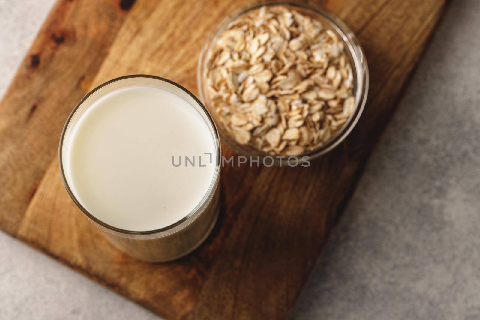 Vegan oat milk with oat flakes close up by Fabrikasimf