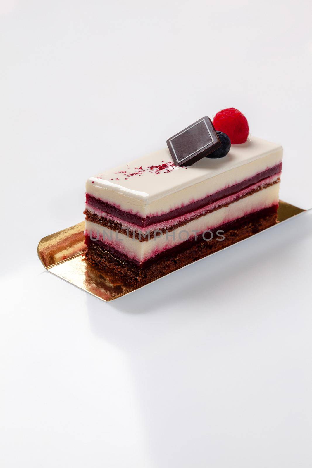 Slice of raspberry dessert with chocolate sponge cake, cream cheese mousse and berry jelly by nazarovsergey