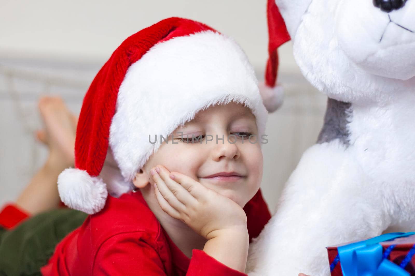 Portrait of a cute boy in a Santa Claus hat. Funny smiling child. Christmas concert.
