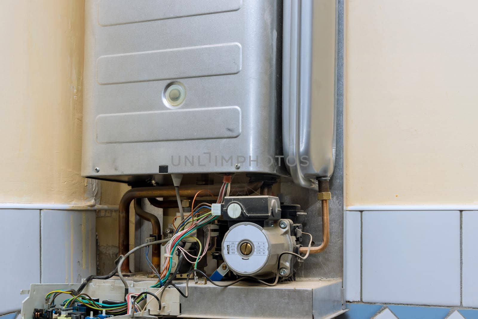Technician servicing on gas boiler for hot water and heating by ungvar