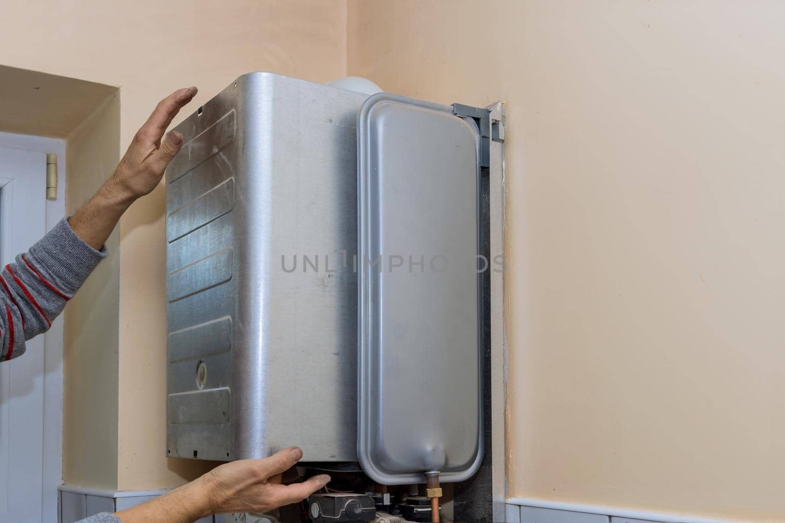 Maintenance service engineer working with home gas heating boiler by ungvar