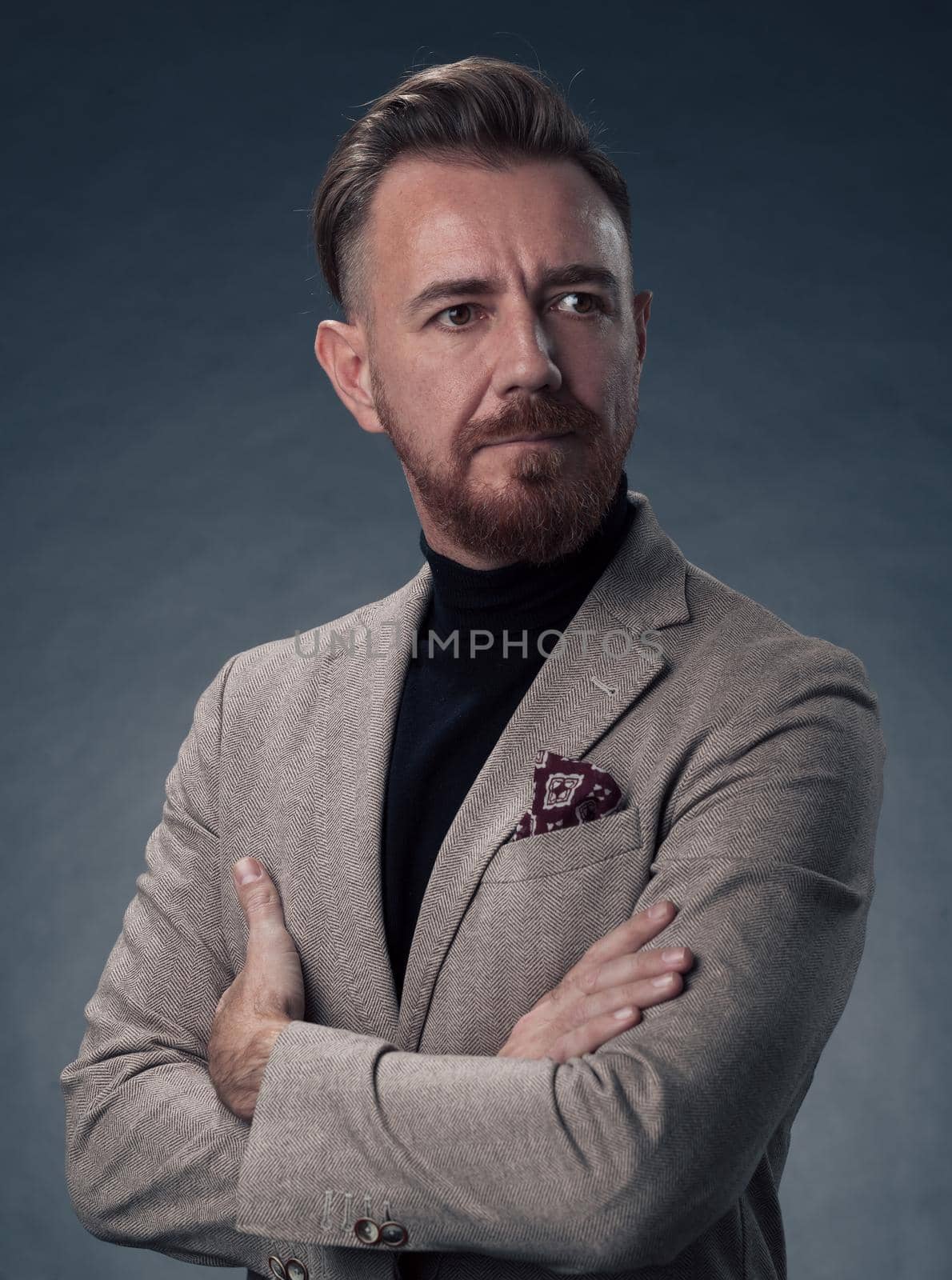 Portrait of a stylish elegant senior businessman with a beard and casual business clothes in photo studio isolated on dark background gesturing with hands by dotshock