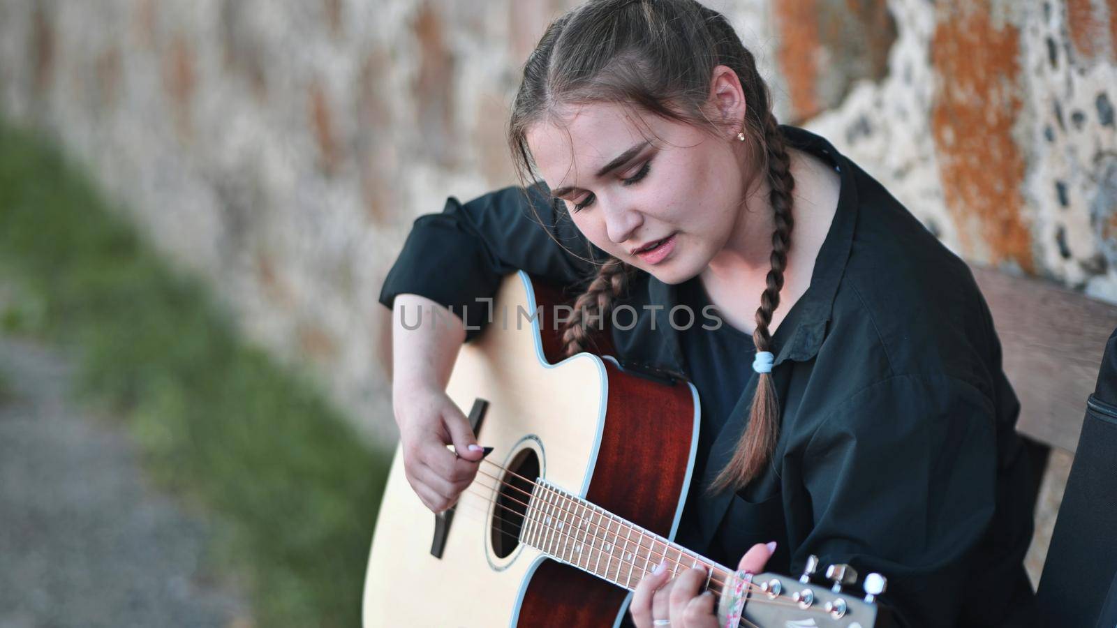 Cute girl plays the guitar in the park