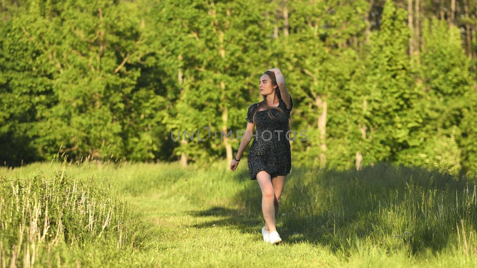 A young girl runs in a meadow on a warm summer evening. by DovidPro