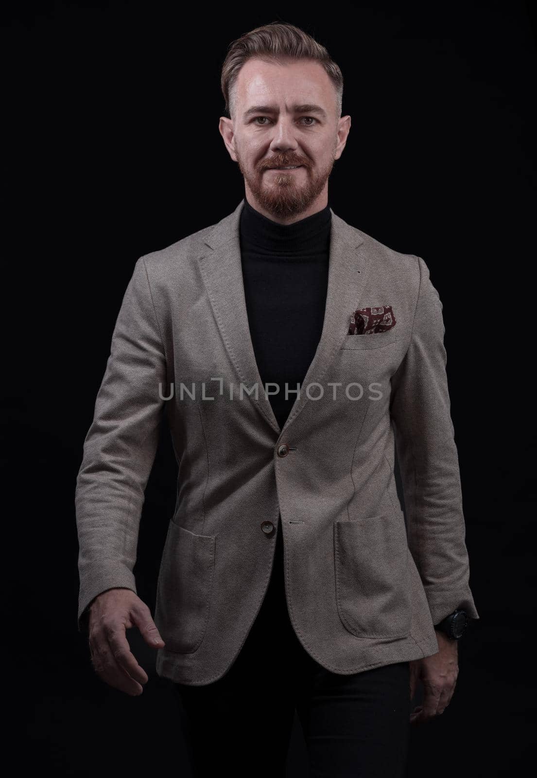 Confident businessman walking forward wearing a causal suit, handsome senior business man hero shot portrait isolated on black by dotshock