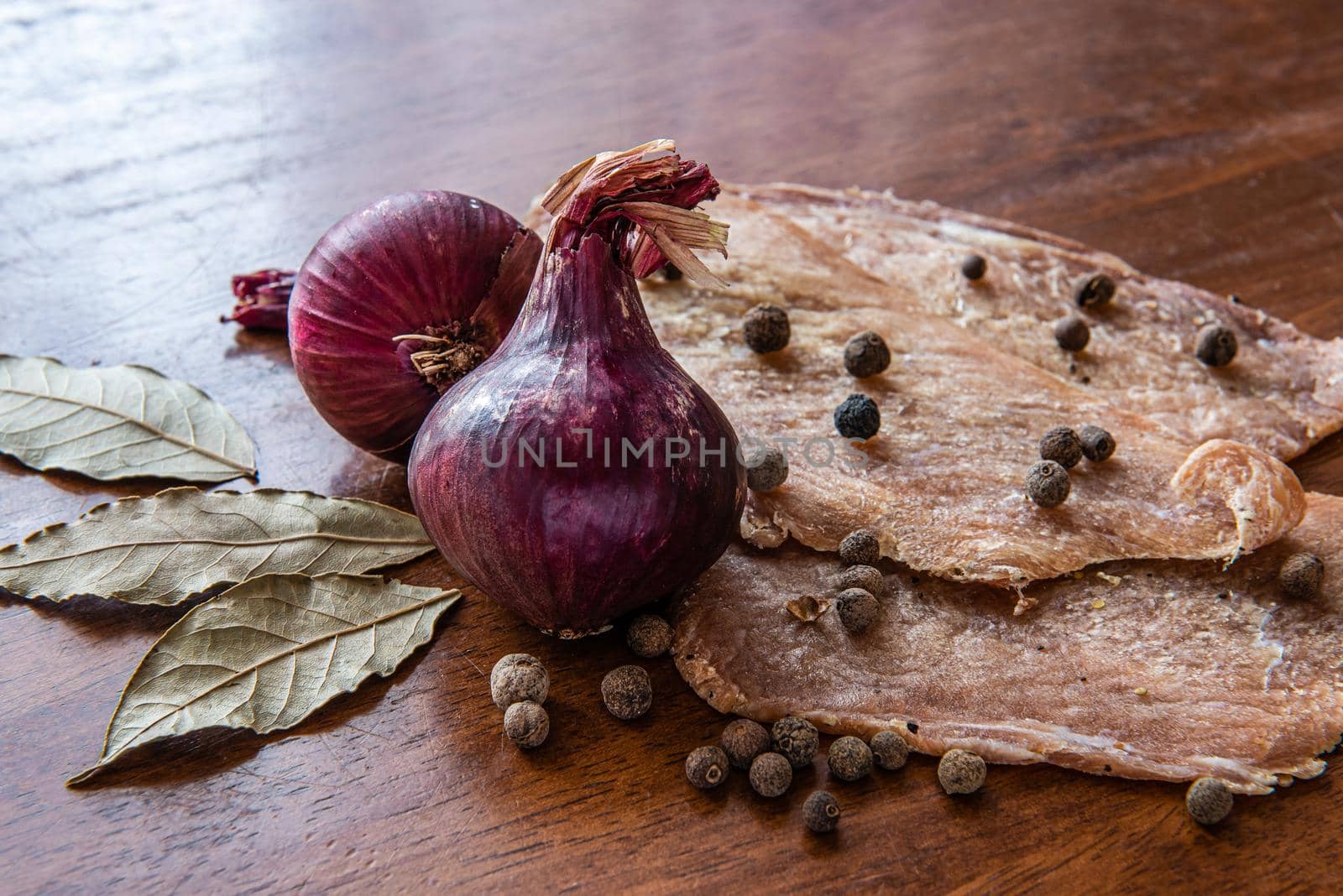 Jerky with spices, onions and herbs on an old wooden table. Beer snack by karpovkottt