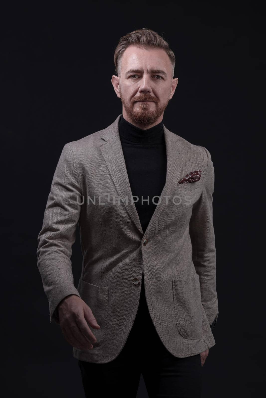 Confident businessman walking forward wearing a causal suit, handsome senior business man hero shot portrait isolated on black by dotshock