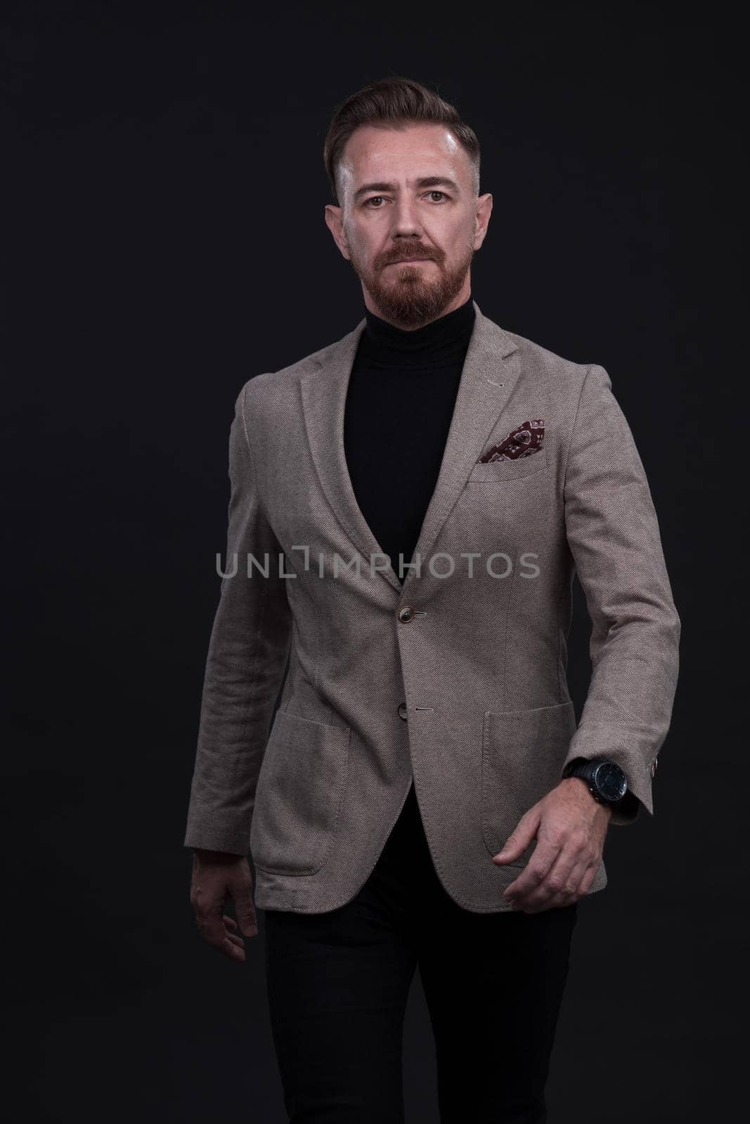 Confident businessman walking forward wearing a causal suit, handsome senior business man hero shot portrait isolated on black. High quality photo