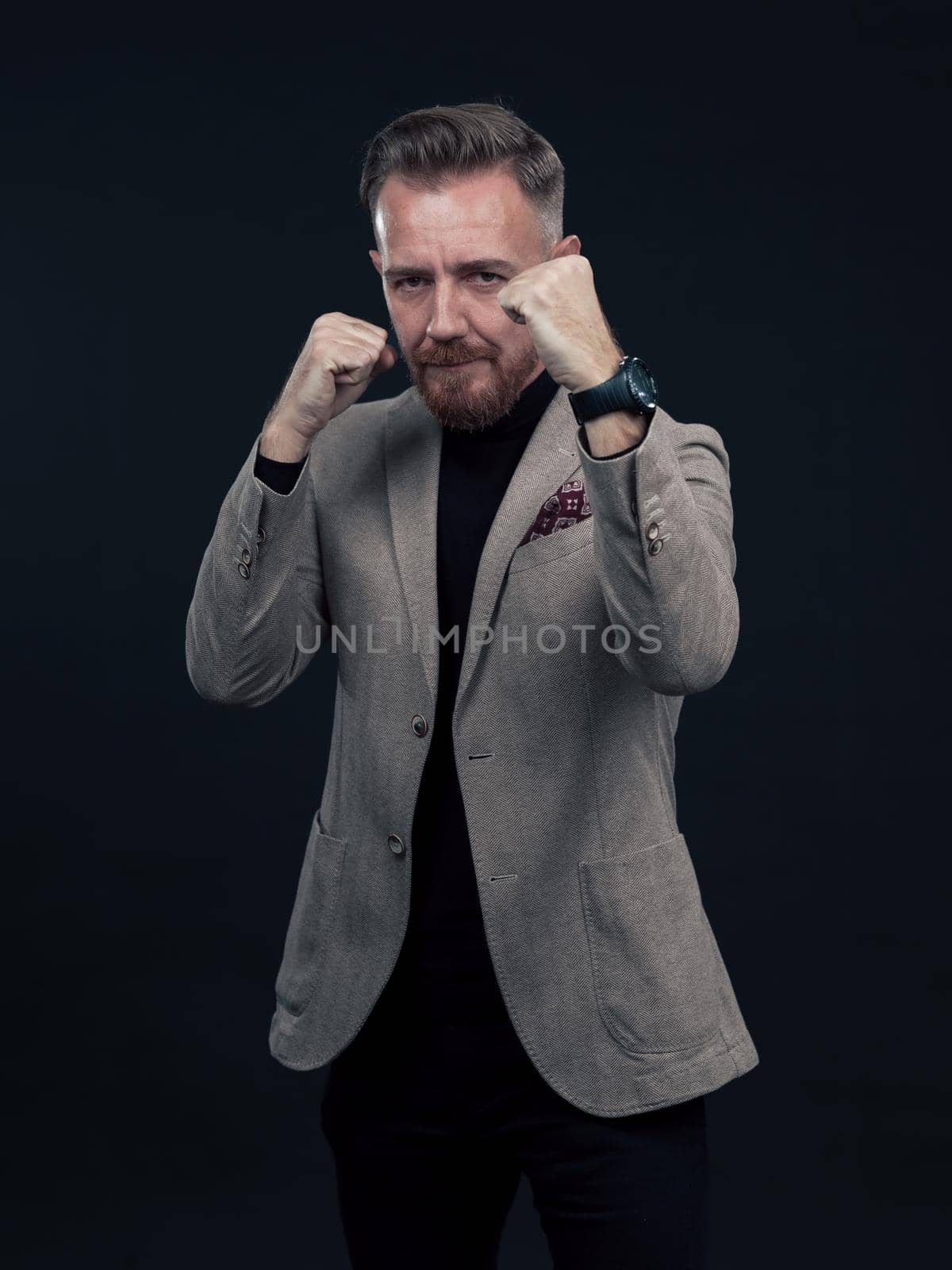 Portrait of a stylish elegant senior businessman with a beard and casual business clothes ready to fight hands gesture by dotshock