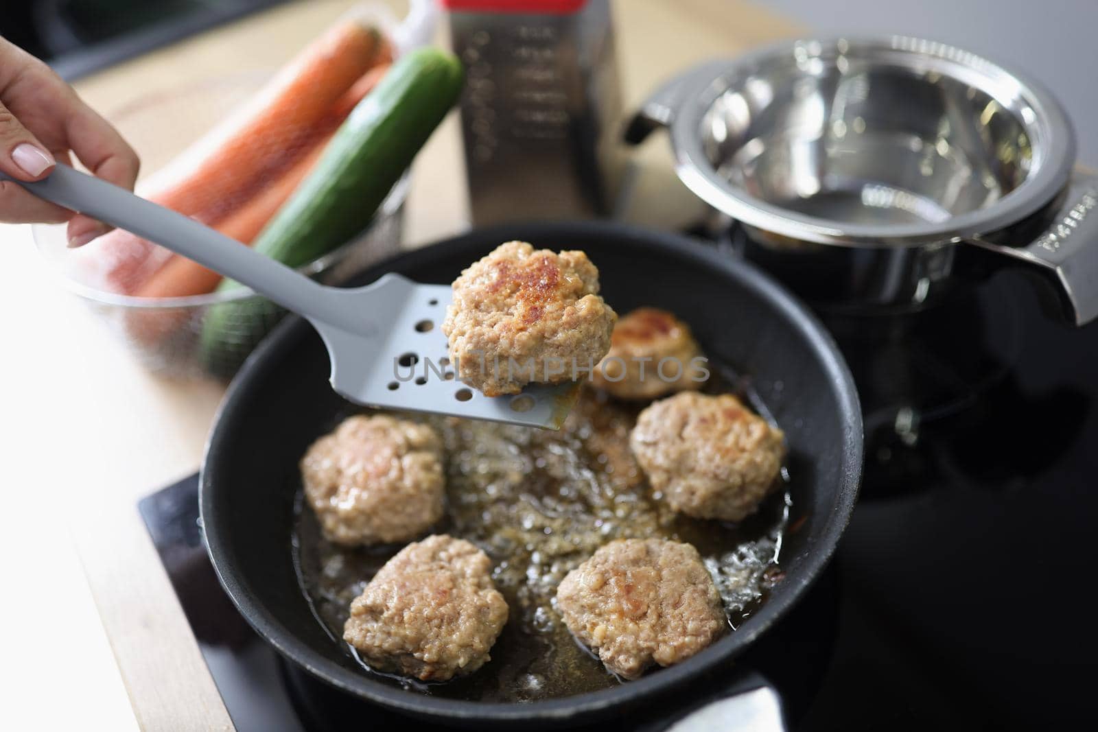 Close-up of tasty aromatic meat balls frying in oil on pan on kitchen stove. Housewife cooking yum meal using tool. Chef, food, eating, nutritious concept