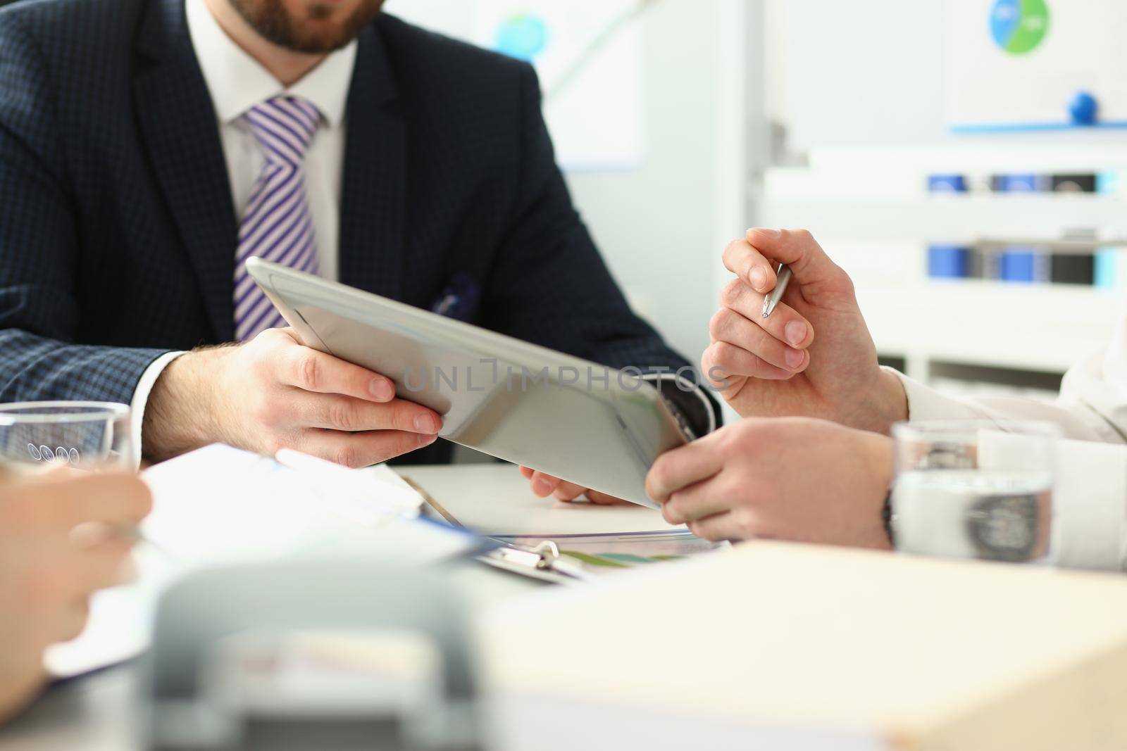 Close-up of manager holding special pen and paper tablet with document to sign. Discussing contract that determine corporation future. Strategy concept