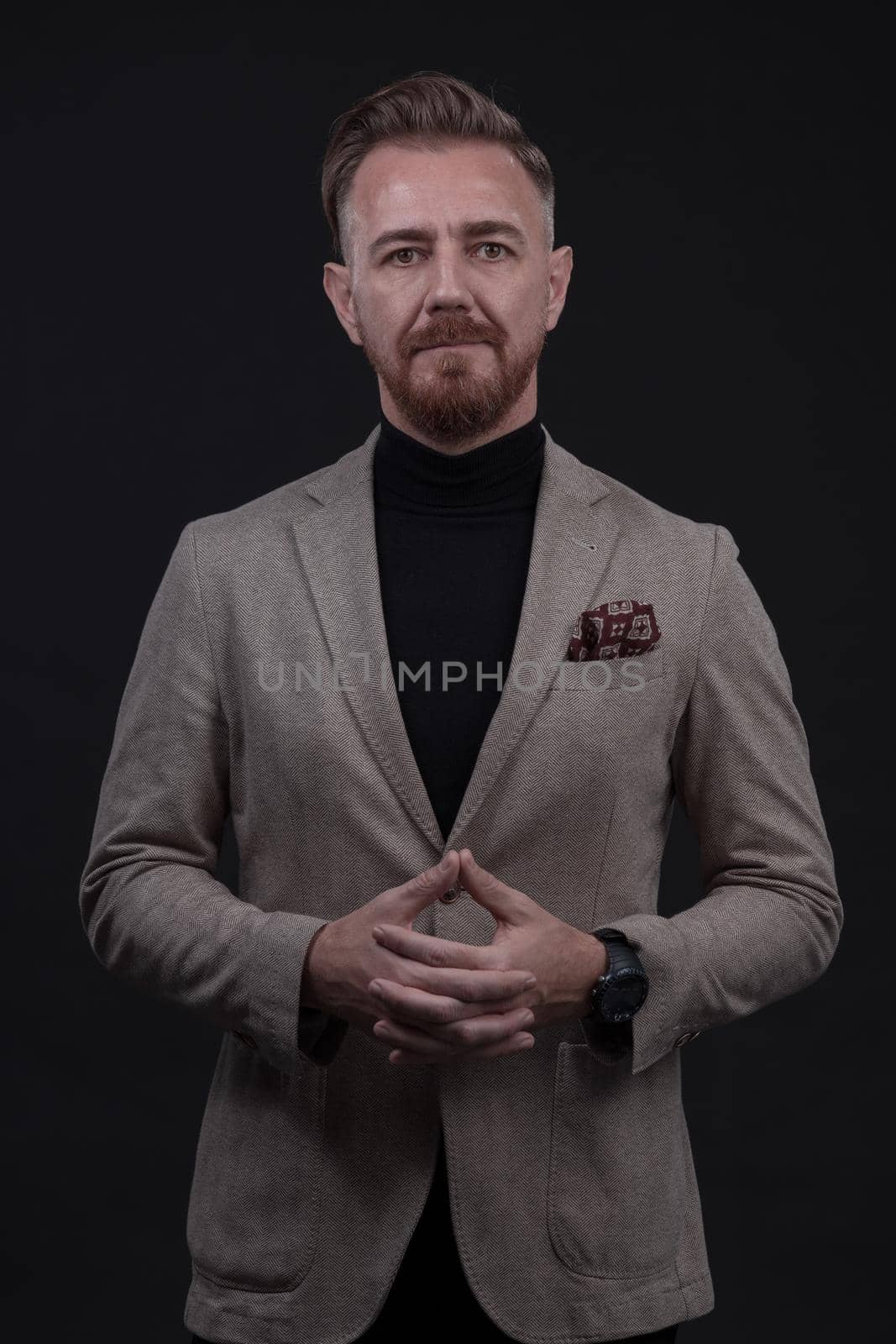 Portrait of a stylish elegant senior businessman with a beard and casual business clothes in photo studio isolated on dark background gesturing with hands by dotshock