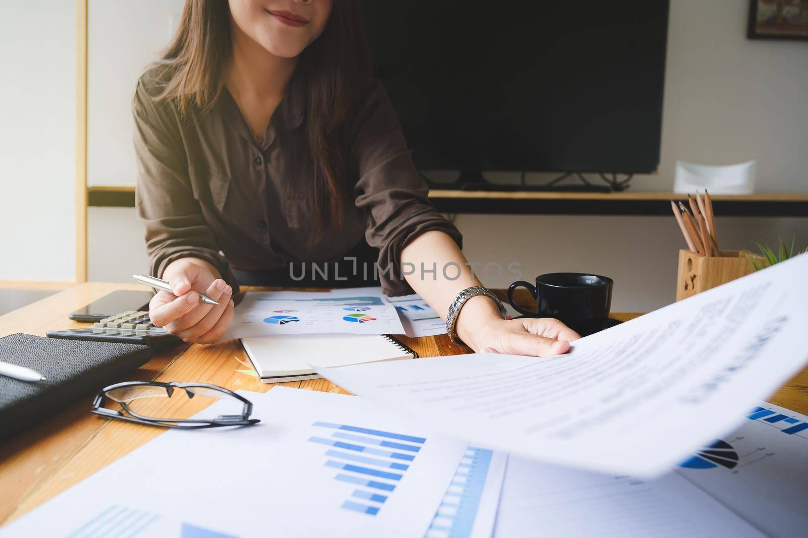 Close up Business woman hand holding pen and financial paperwork with financial network diagram. vintage concept.