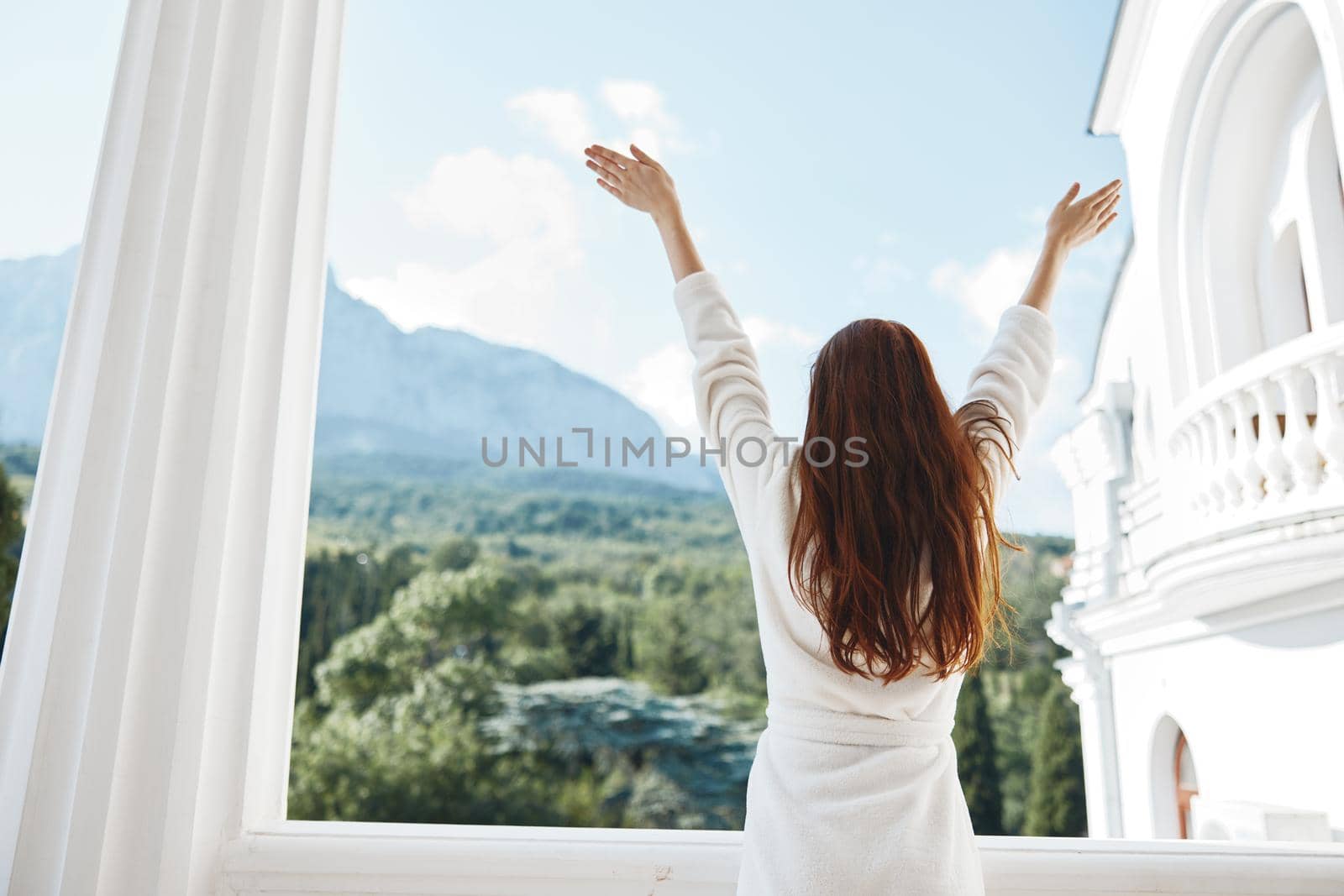 beautiful woman looks at a beautiful view from the balcony Mountain View. High quality photo