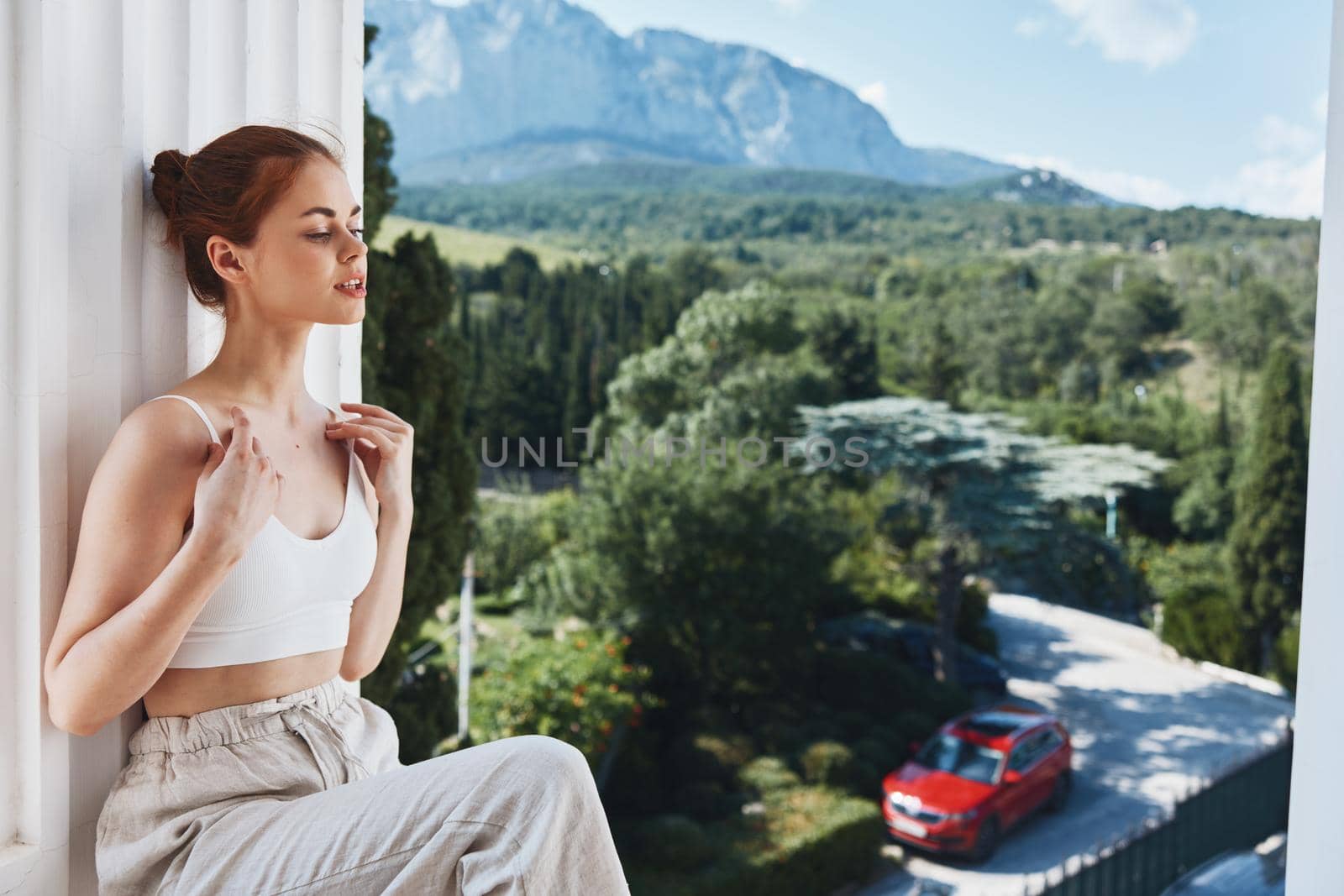 beautiful woman in white t-shirt on the balcony in the mountains by SHOTPRIME