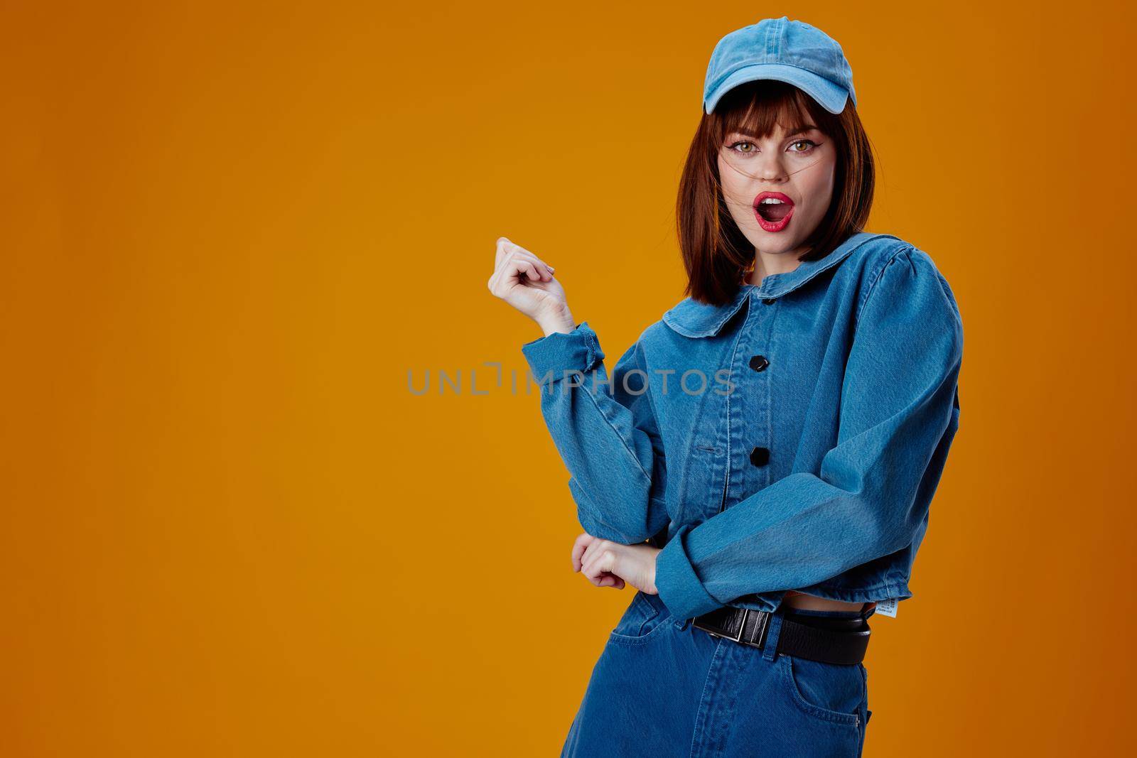 Portrait of a charming lady denim cap red lips glamor fashion color background unaltered. High quality photo