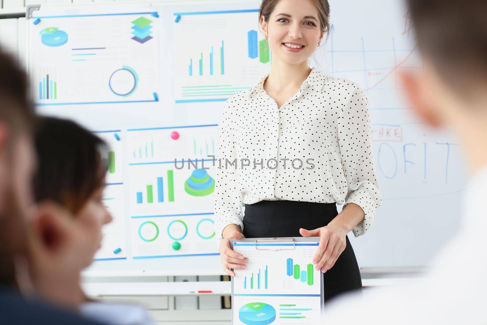 Portrait of businesswoman explain and show plan for development, board with goals for next year, prepared report of done work. Business, strategy concept